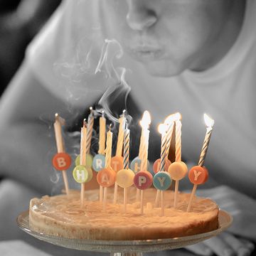 boy blowing out birthday candles on cake