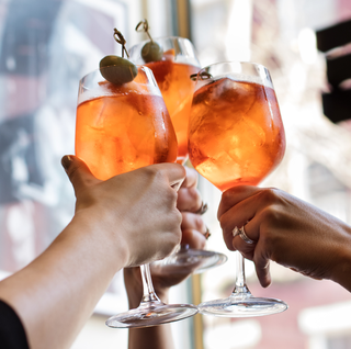 three women clinking cocktails for a cheers at dante in nyc