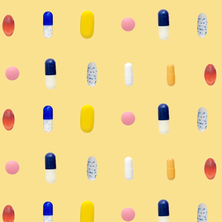 a bunch of different coloredshaped pills in rows on yellow background